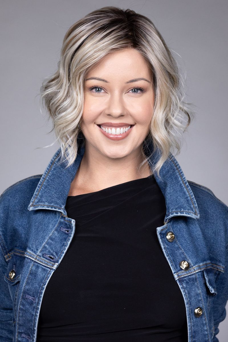 Clare Wig by Belle Tress in Butterbeer R 10/60/88+8 | Butterbeer Root hair color is an inviting blend that exudes a cozy, radiant charm. The roots feature soft dimensions of brown base with a touch of depth, giving a natural and lived-in look. This transitions smoothly into a buttery blonde, infused with creamy honey and toffee tones that shimmer like the frothy top of a freshly poured butterbeer.