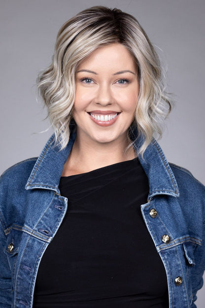 Clare Wig by Belle Tress in Butterbeer R 10/60/88+8 | Butterbeer Root hair color is an inviting blend that exudes a cozy, radiant charm. The roots feature soft dimensions of brown base with a touch of depth, giving a natural and lived-in look. This transitions smoothly into a buttery blonde, infused with creamy honey and toffee tones that shimmer like the frothy top of a freshly poured butterbeer.