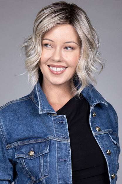 Clare Wig by Belle Tress in Butterbeer R 10/60/88+8 | Butterbeer Root hair color is an inviting blend that exudes a cozy, radiant charm. The roots feature soft dimensions of brown base with a touch of depth, giving a natural and lived-in look. This transitions smoothly into a buttery blonde, infused with creamy honey and toffee tones that shimmer like the frothy top of a freshly poured butterbeer.