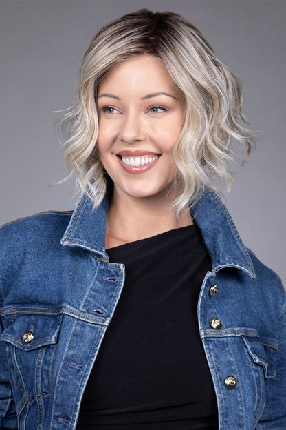 Clare Wig by Belle Tress in Butterbeer R 10/60/88+8 | Butterbeer Root hair color is an inviting blend that exudes a cozy, radiant charm. The roots feature soft dimensions of brown base with a touch of depth, giving a natural and lived-in look. This transitions smoothly into a buttery blonde, infused with creamy honey and toffee tones that shimmer like the frothy top of a freshly poured butterbeer.